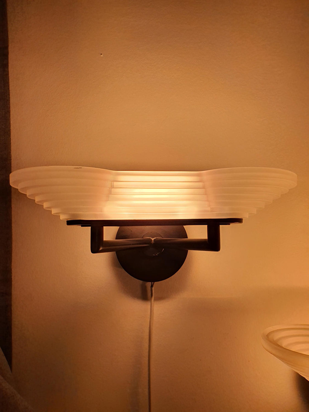 Vintage Italian Memphis Postmodern wall light unlit, showing stepped pyramid satin glass silhouette and black metal base
