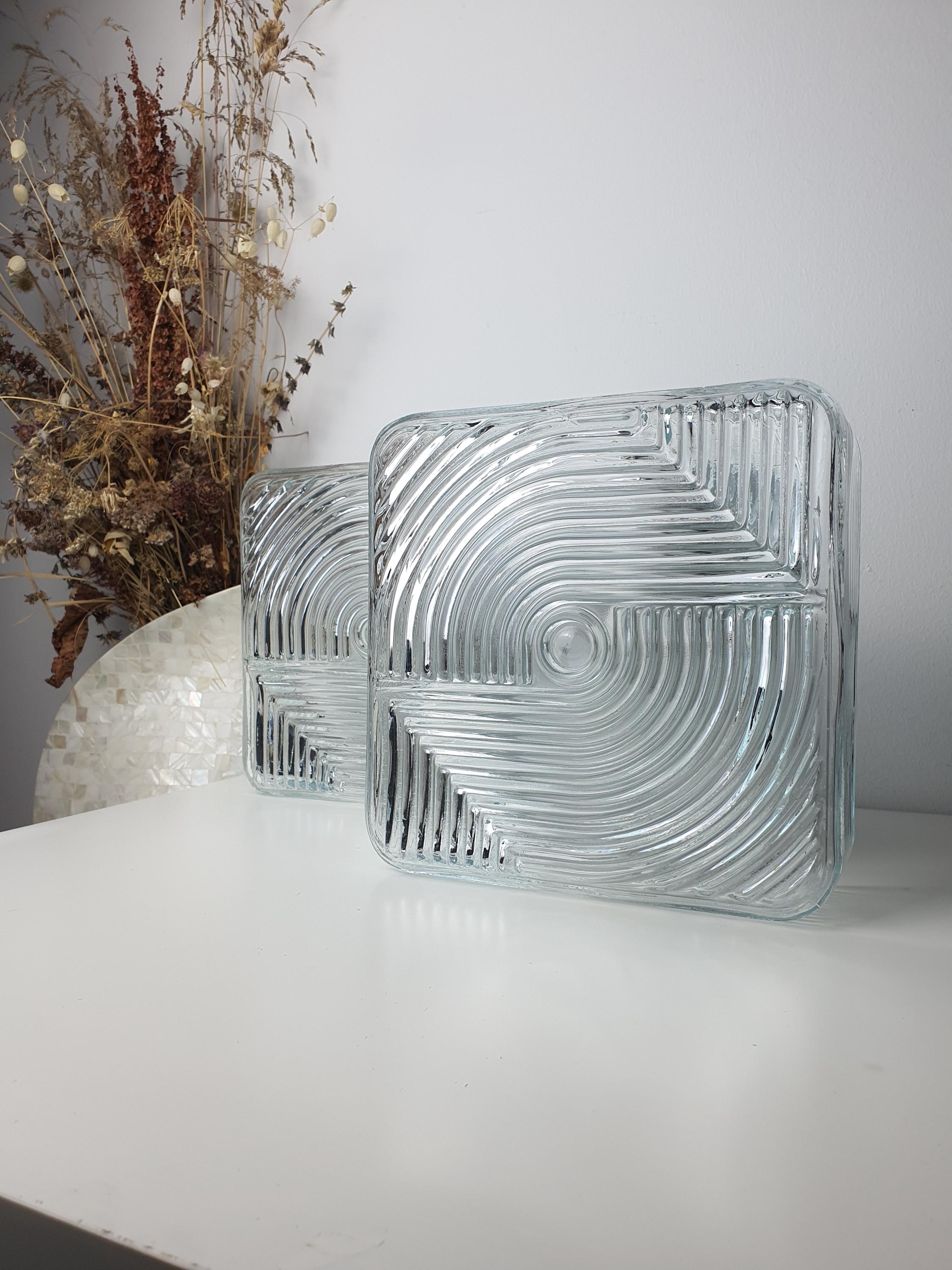 Close-up of textured stamped clear glass on vintage square Brutalist MCM wall sconce, architectural light refraction