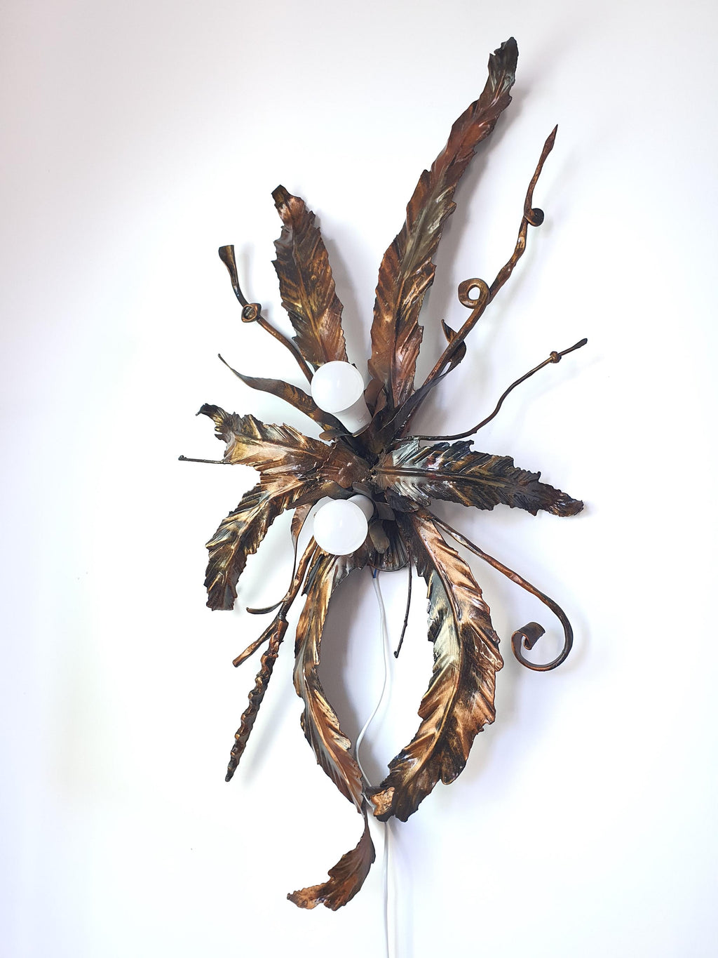Handcrafted gilded metal wall light with a floral-inspired sculptural design
