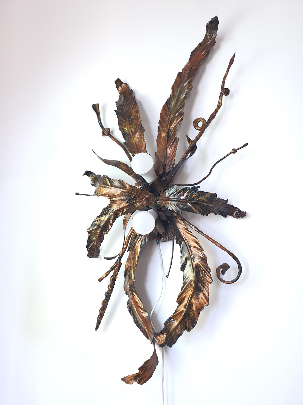 Handcrafted gilded metal wall light with a floral-inspired sculptural design
