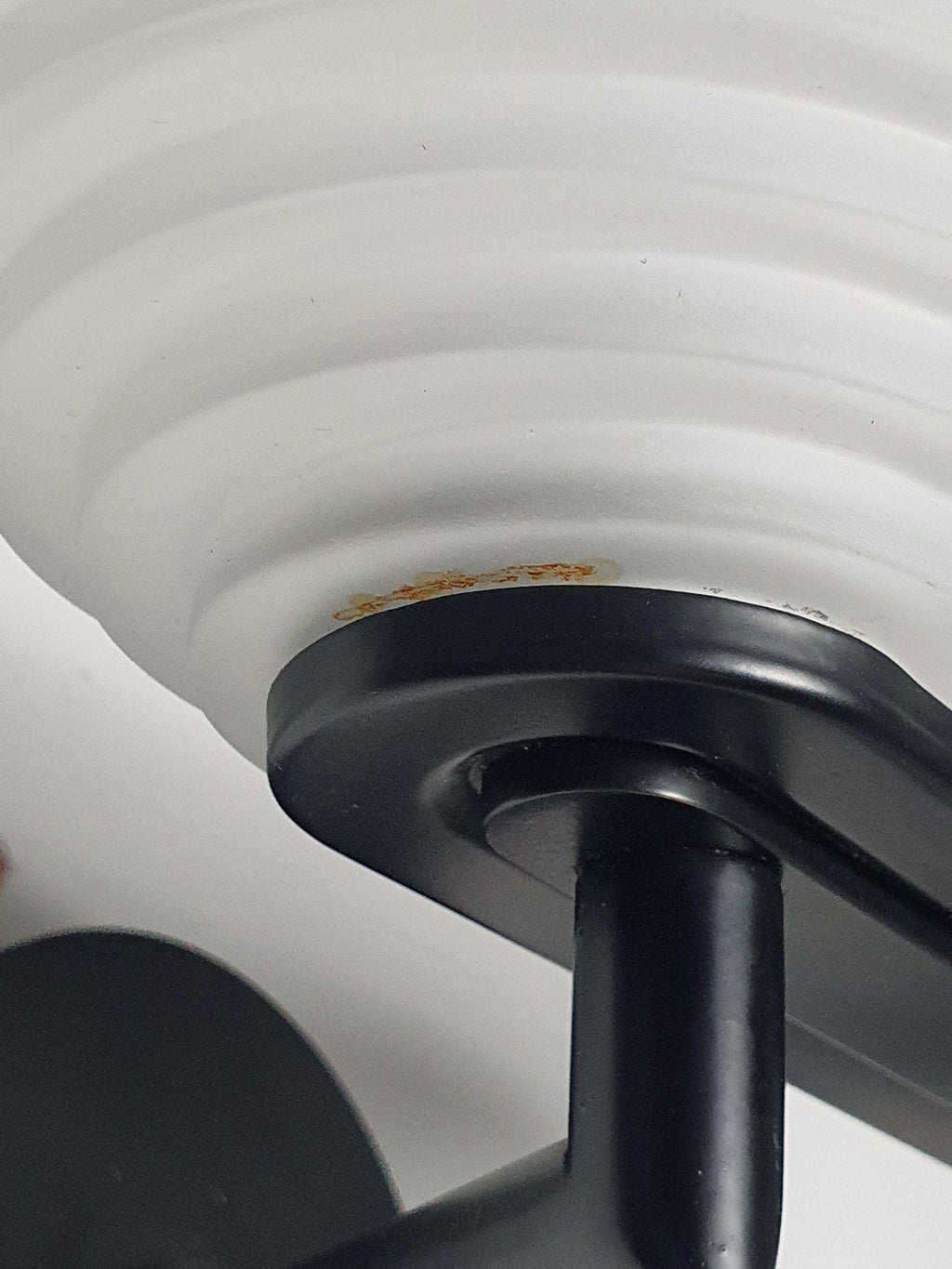 Close-up of stepped pyramid satin glass diffuser on vintage Italian Memphis Postmodern wall light, geometric layered form