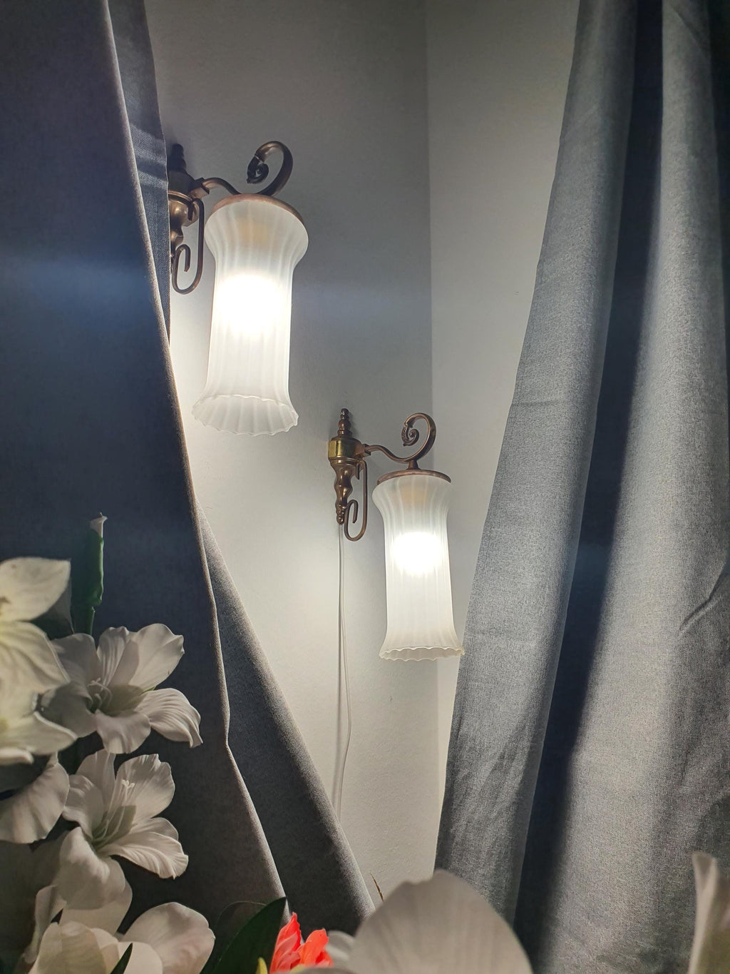 Vintage Italian satin frosted flute wall sconce in bathroom, elongated flute form, brass base, soft ambient light