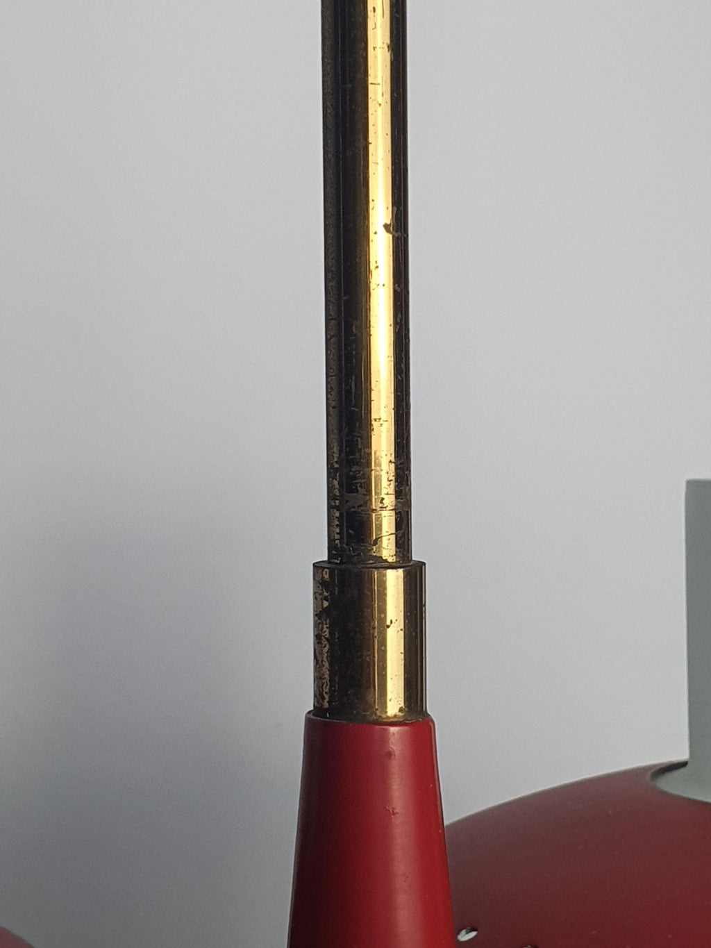 Vintage Stilnovo style chandelier — brass structure and red matte metal close-up