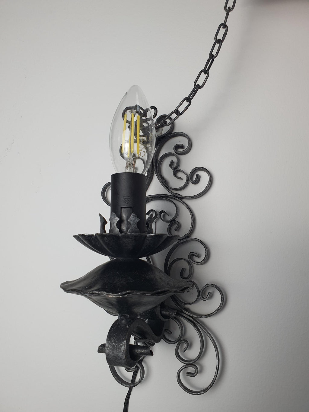 Gothic wrought iron wall sconce — artisanal forged metalwork and sculptural silhouette detail