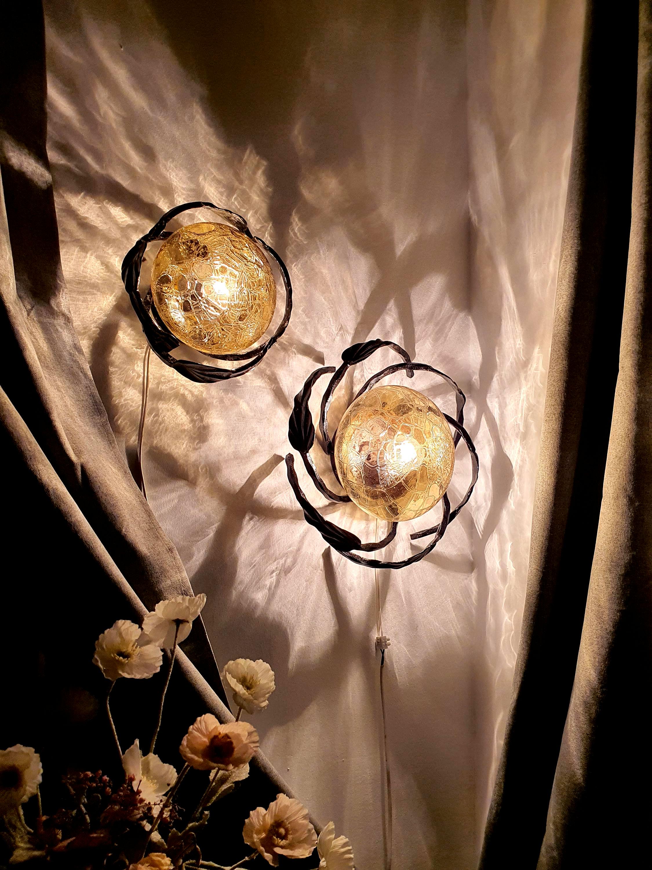 Pair of vintage 1970s Brutalist wrought iron wall sconces, sculptural leaf decoration, honey amber glass diffusers, rewired

