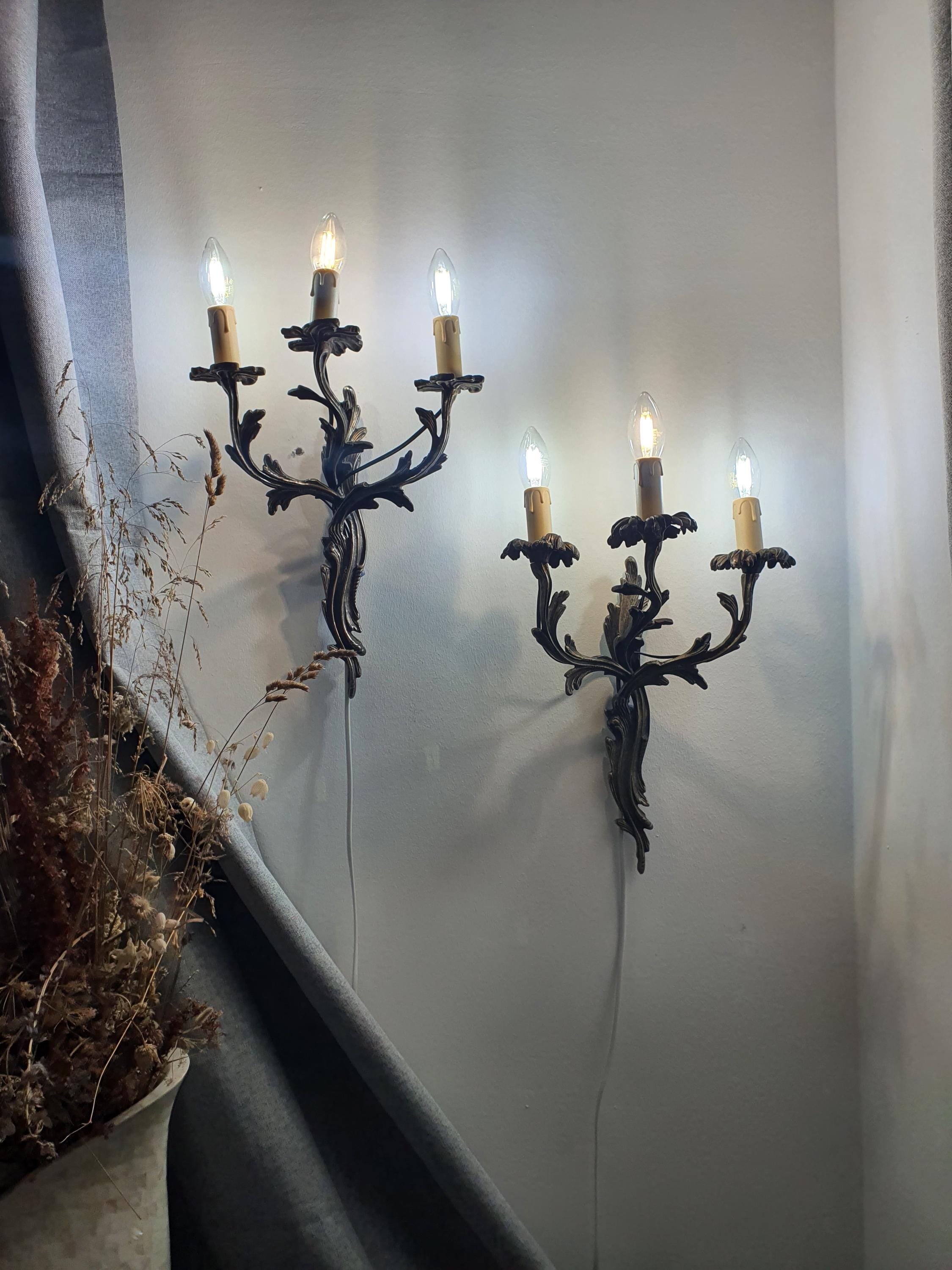 Gothic wall sconce — illuminated, warm candlelight glow from three E14 arms