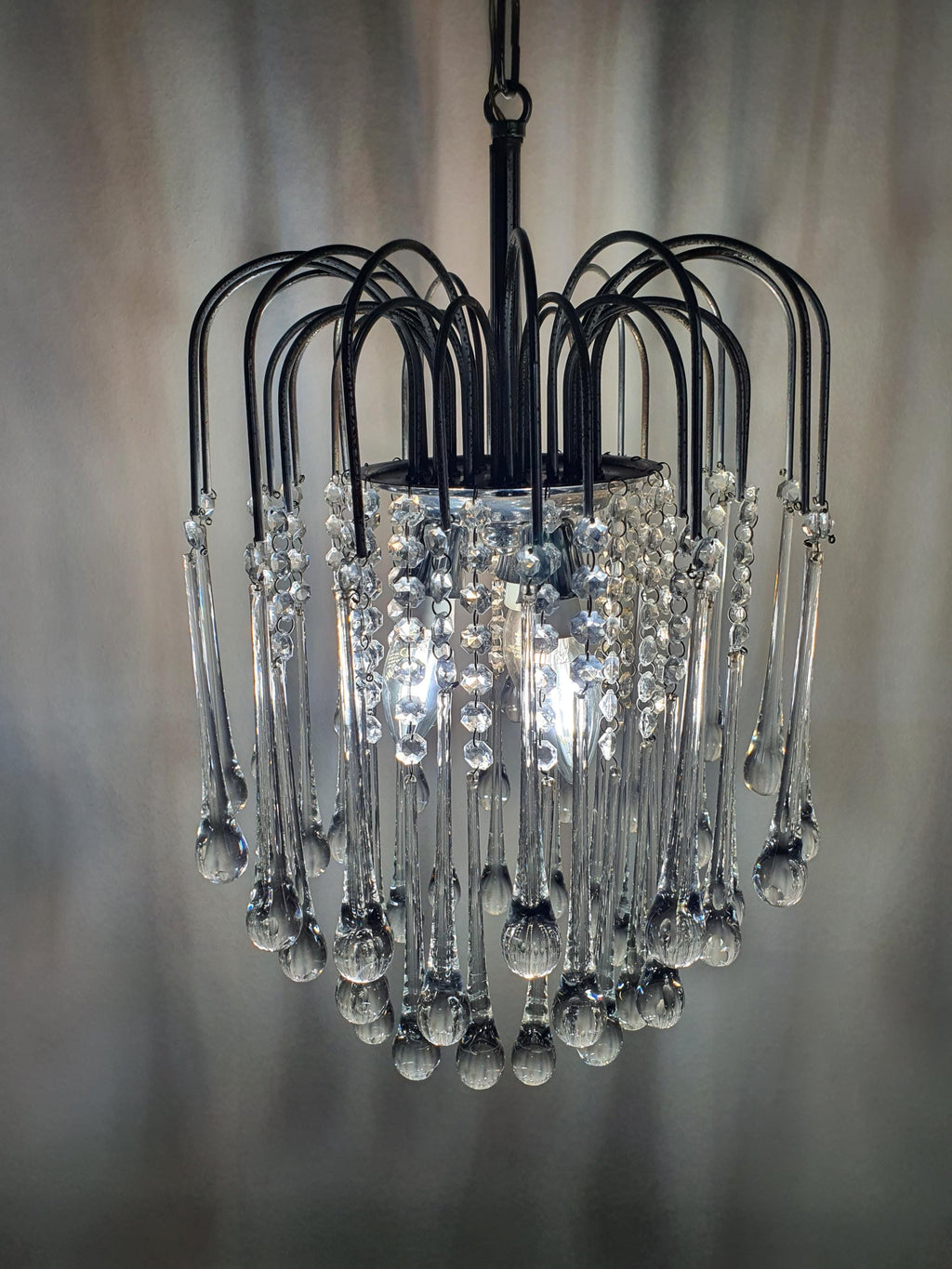 Vintage Murano clear teardrop cascade chandelier in dining nook, clear glass waterfall glow, chrome, glamorous MCM interior
