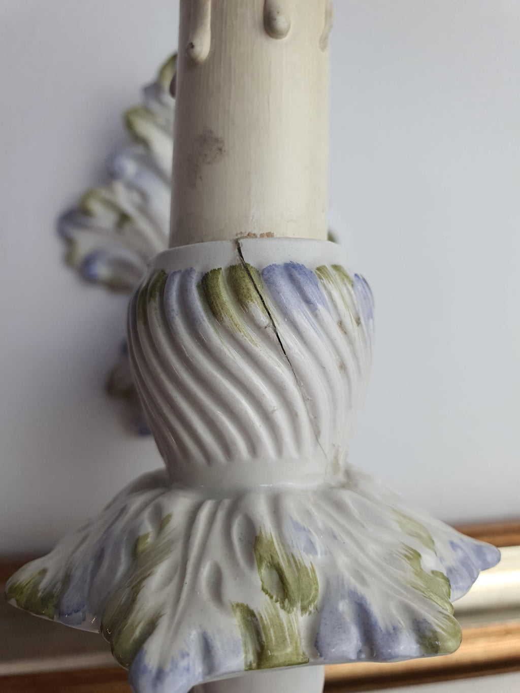 Repaired ceramic bulb-holder support beneath the wall sconce socket
