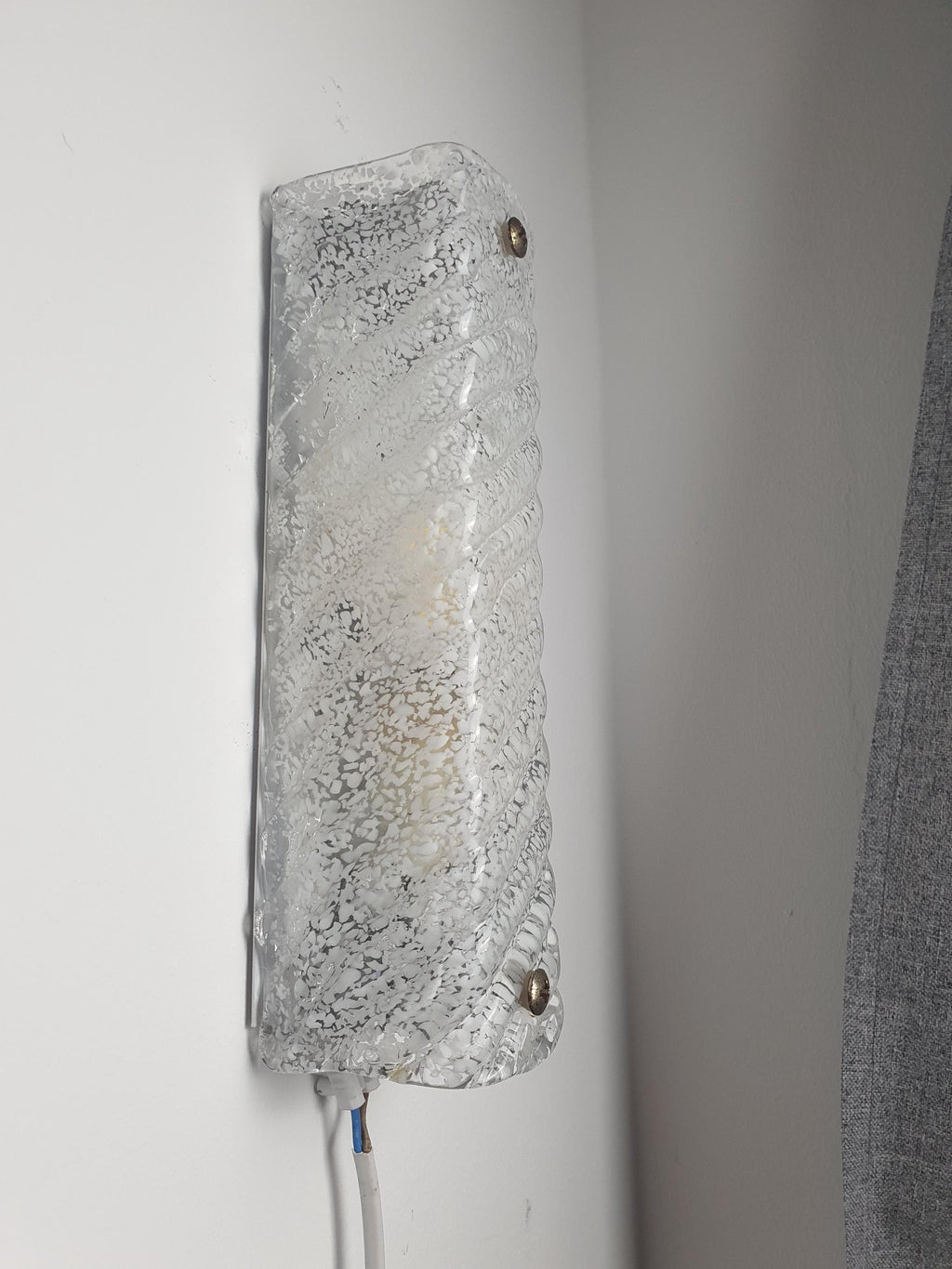 Close-up of deep vertical ribs and white inclusions in icy clear Murano glass rectangular sconce shade