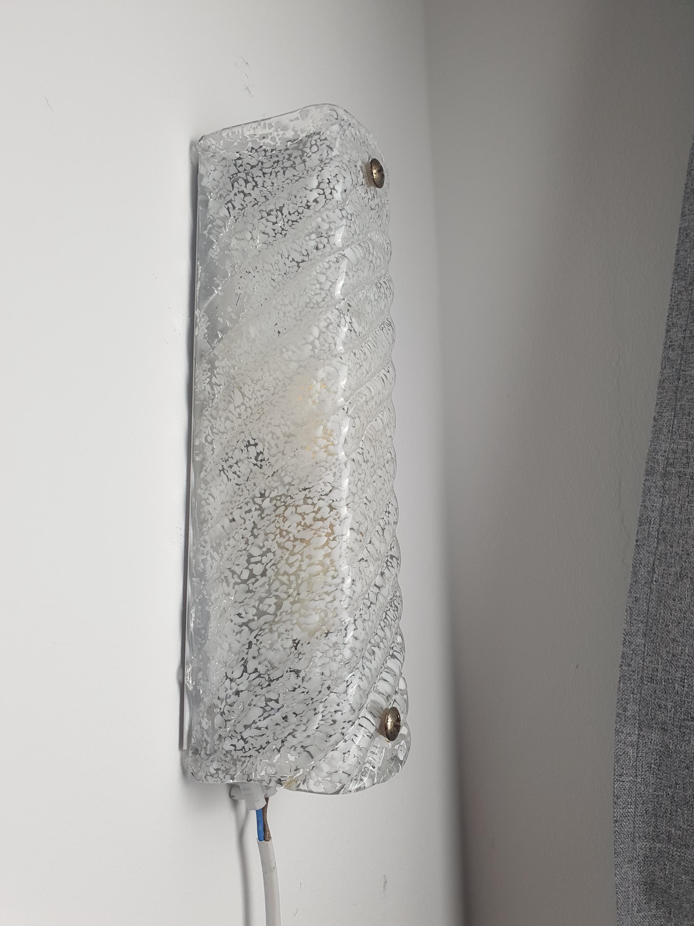 Close-up of deep vertical ribs and white inclusions in icy clear Murano glass rectangular sconce shade