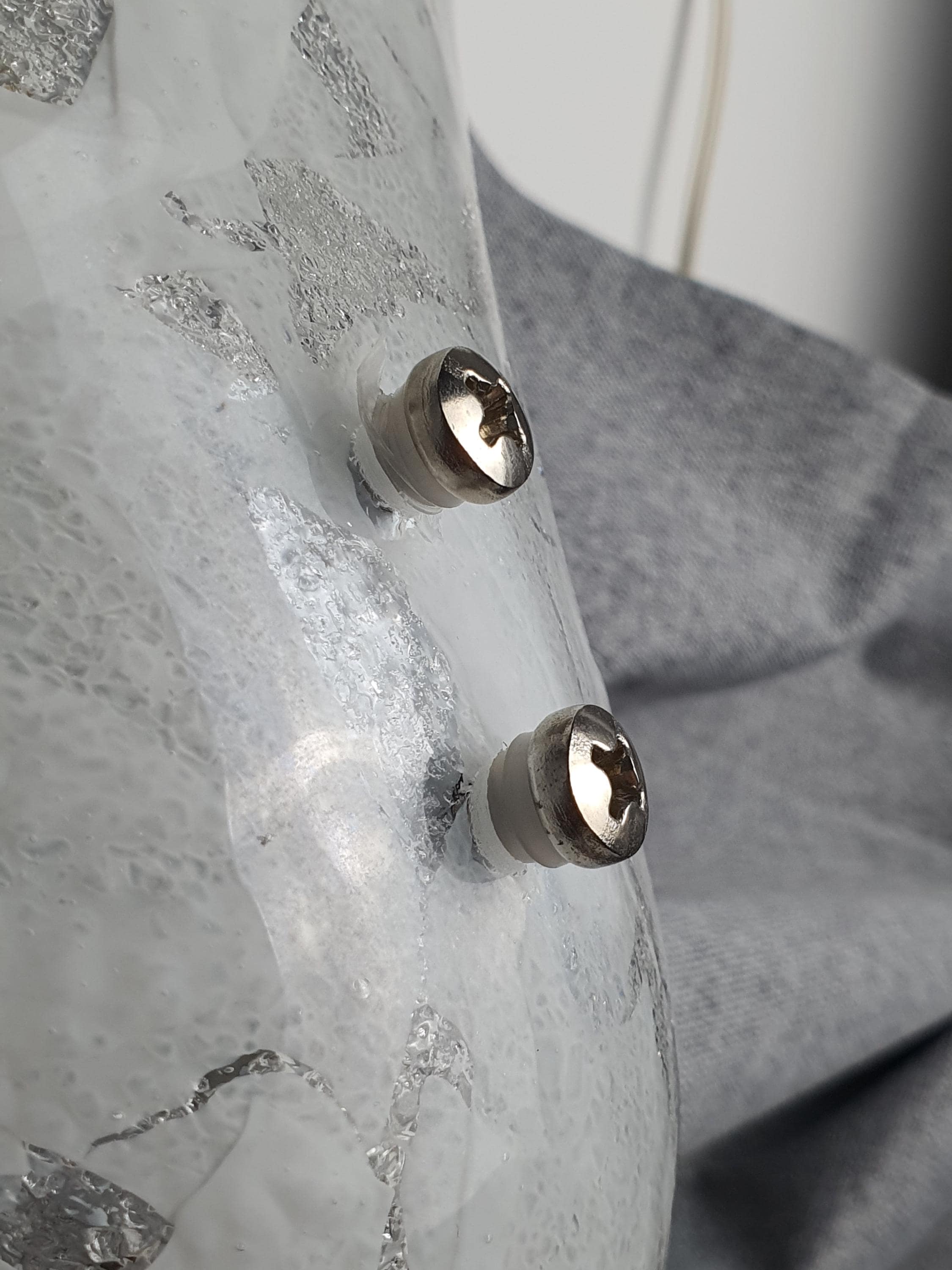 Close-up of white inclusions in clear Murano glass shell sconce shade, dual smooth and satin finish detail