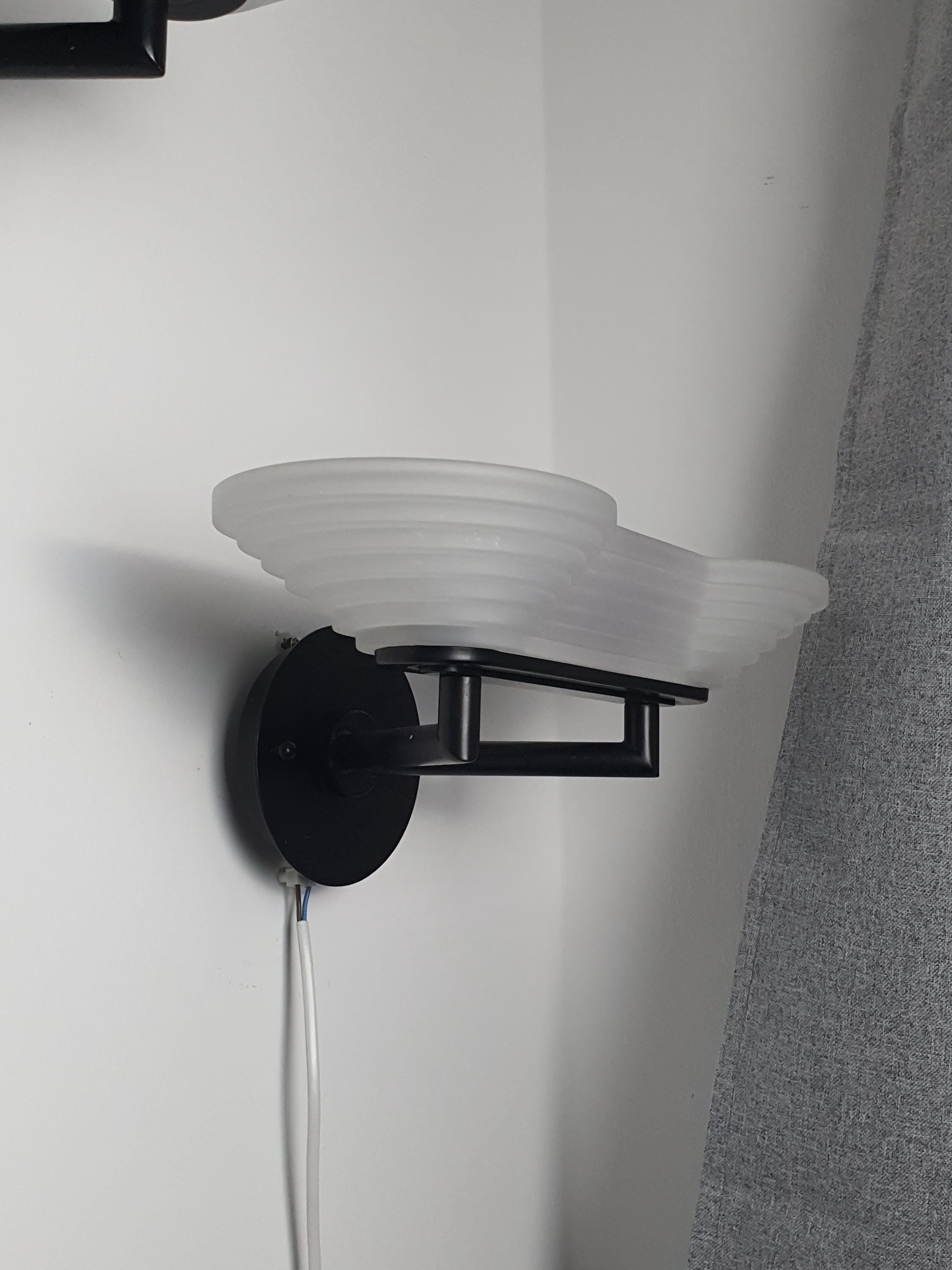 Pair of vintage Italian Memphis Postmodern wall lights in hallway, stepped pyramid satin glass, black metal, bold geometric statement