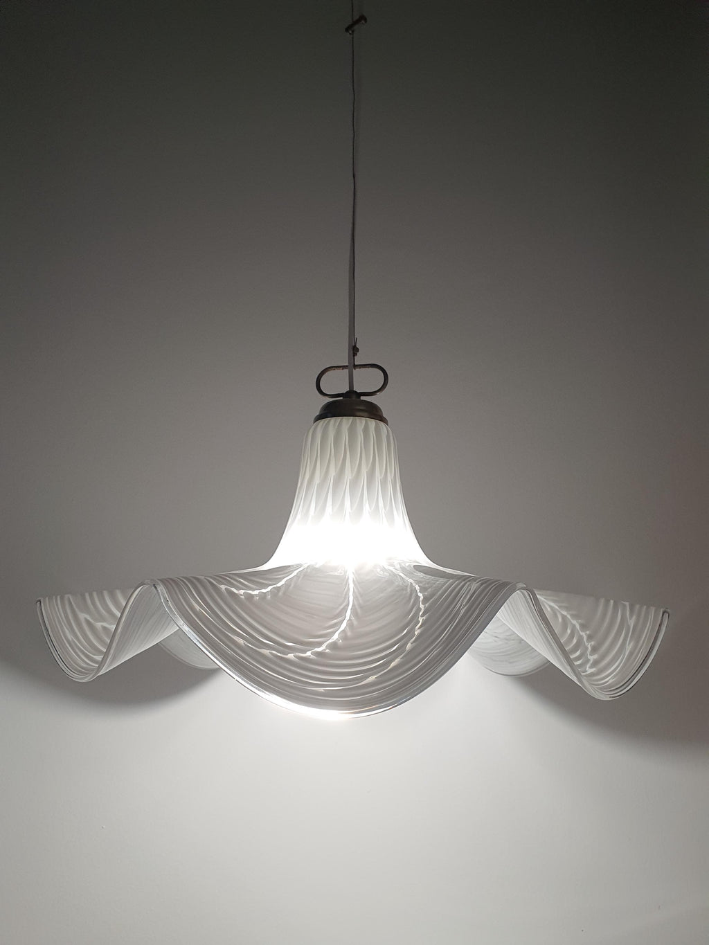 Vintage Murano Fazzoletto pendant installed above dining table, soft organic form, warm glow
