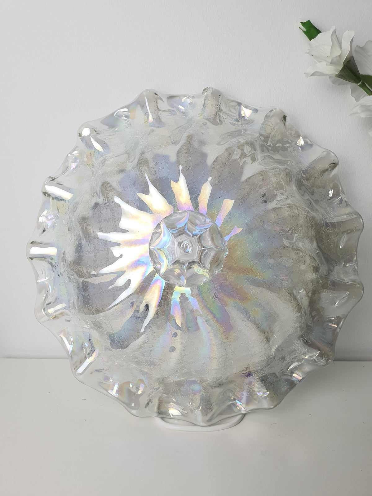 Contrasting smooth and textured surfaces on an iridescent glass shade
