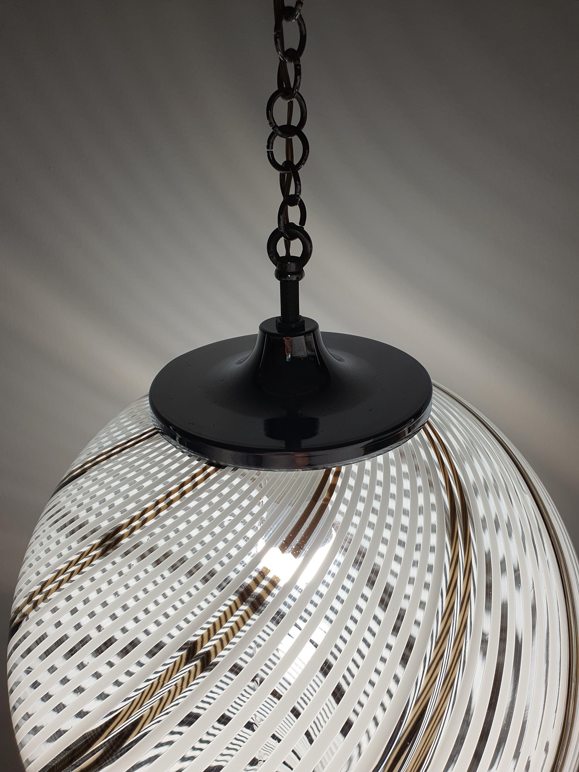 Vintage Italian filigrana globe pendant unlit, showing white and brown swirl glass texture