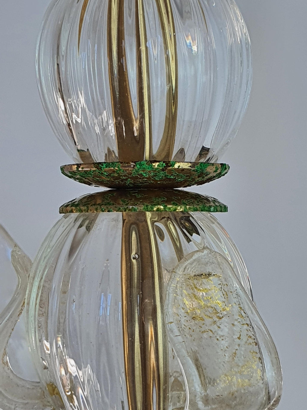 Significant oxidation and patina on a vintage chandelier’s gold-toned metal frame
