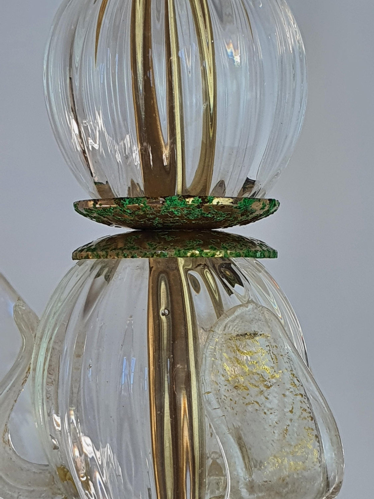 Significant oxidation and patina on a vintage chandelier’s gold-toned metal frame

