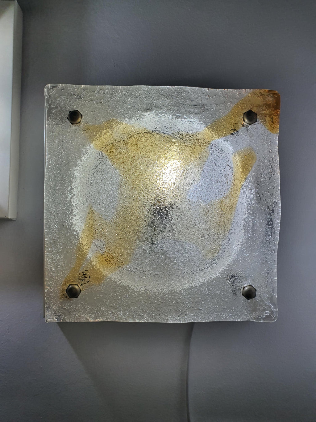 Organic uneven relief and amber inclusions contrast on vintage Mazzega Murano ghiacciato square light, Brutalist Italian design