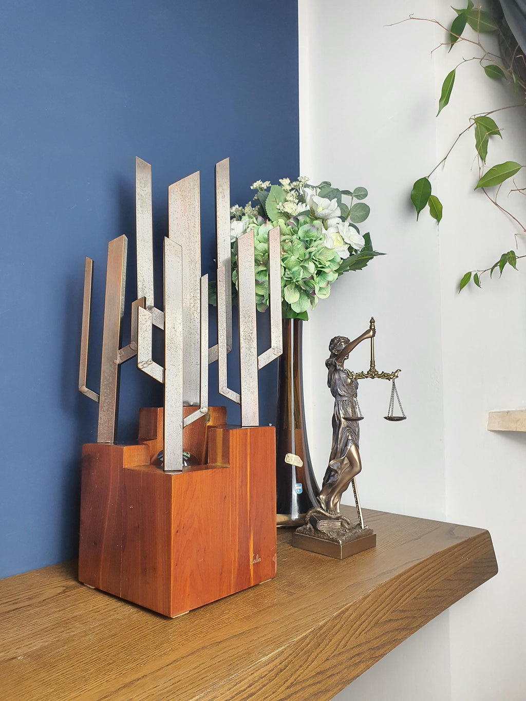 Signed Carlo Brutalist lamp as desk light, vertical metal sculpture on wood cube, moody industrial interior