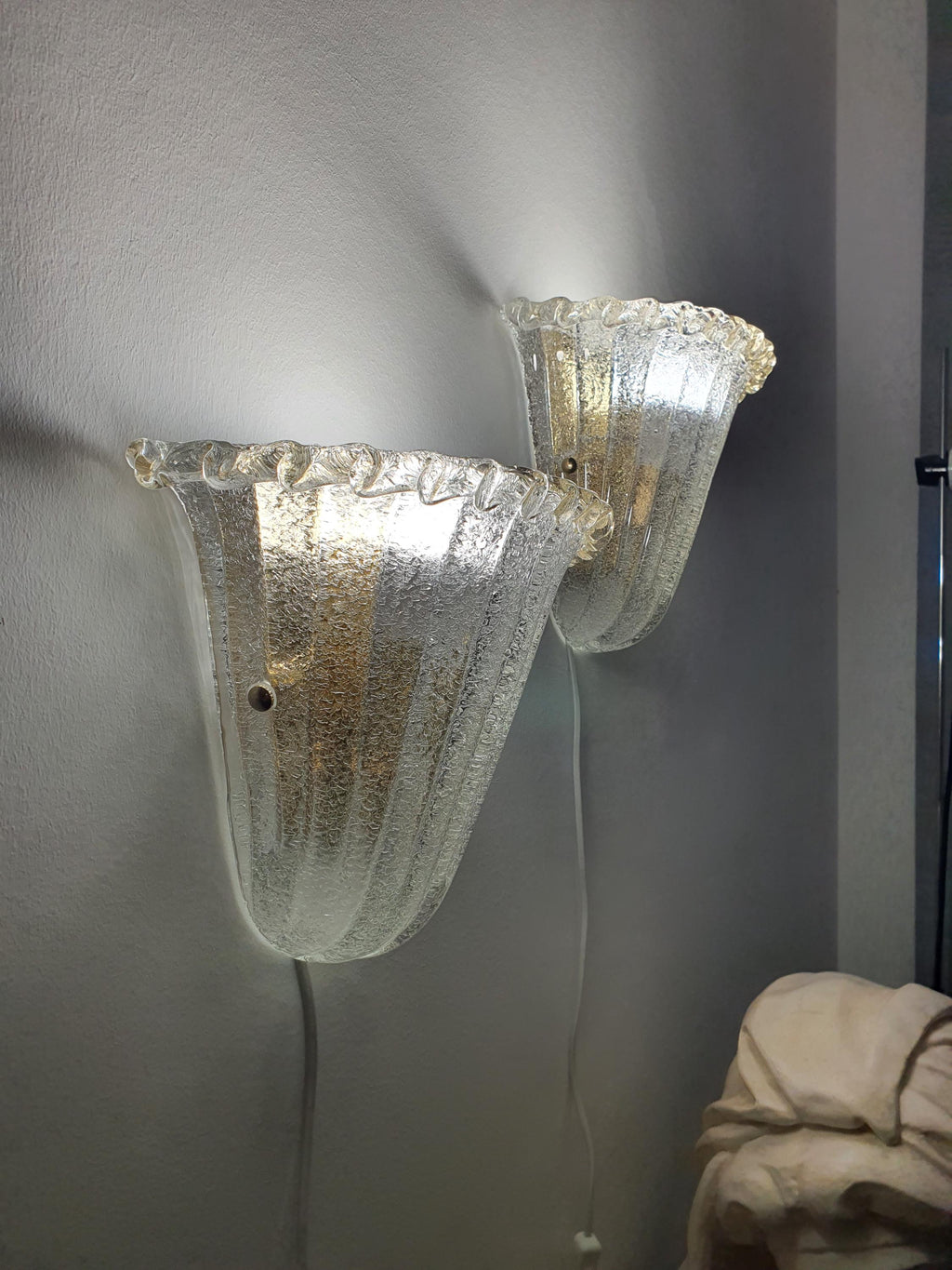 Different decorative shade-fixing screws on vintage Murano shell sconces
