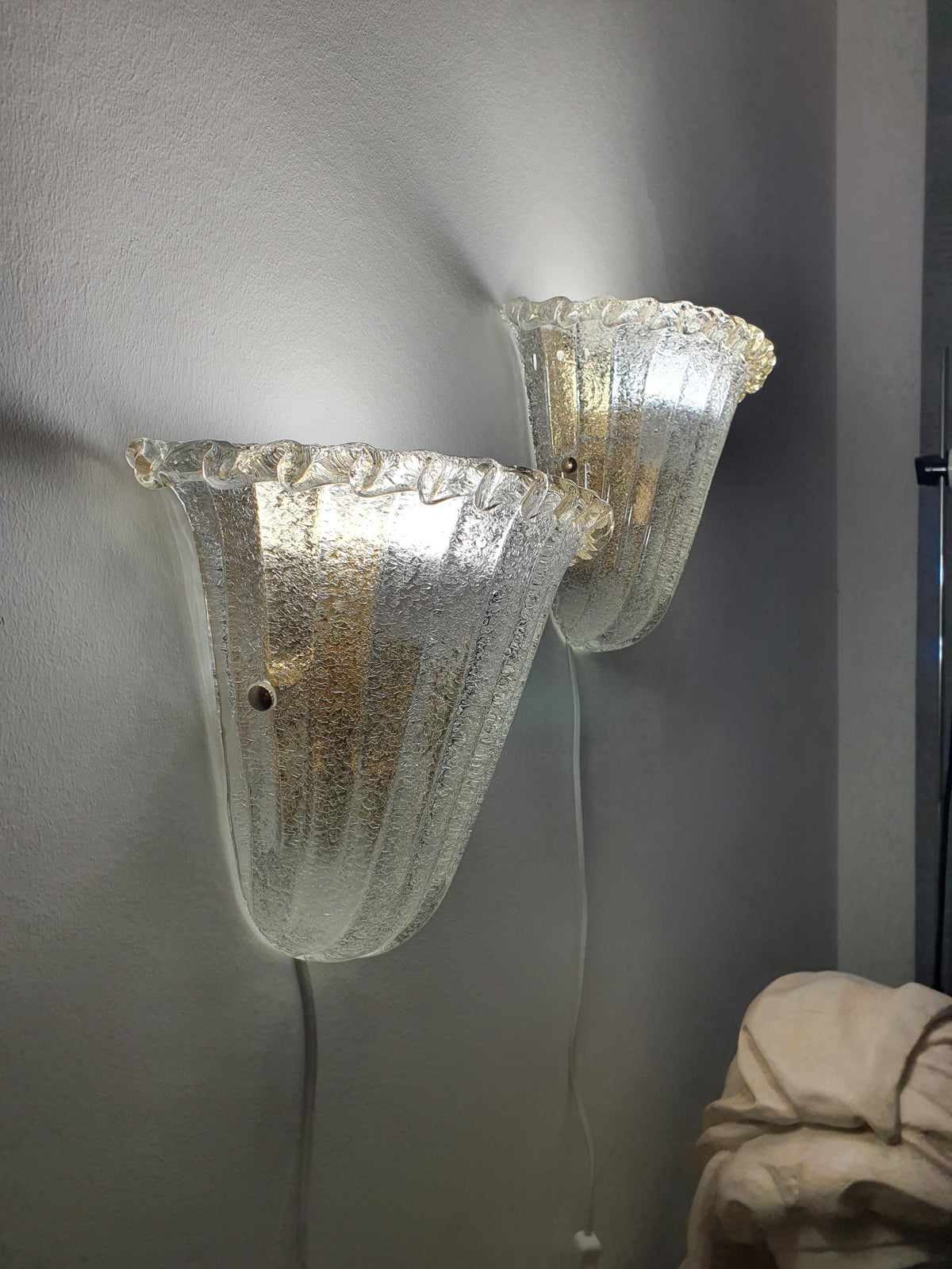Different decorative shade-fixing screws on vintage Murano shell sconces
