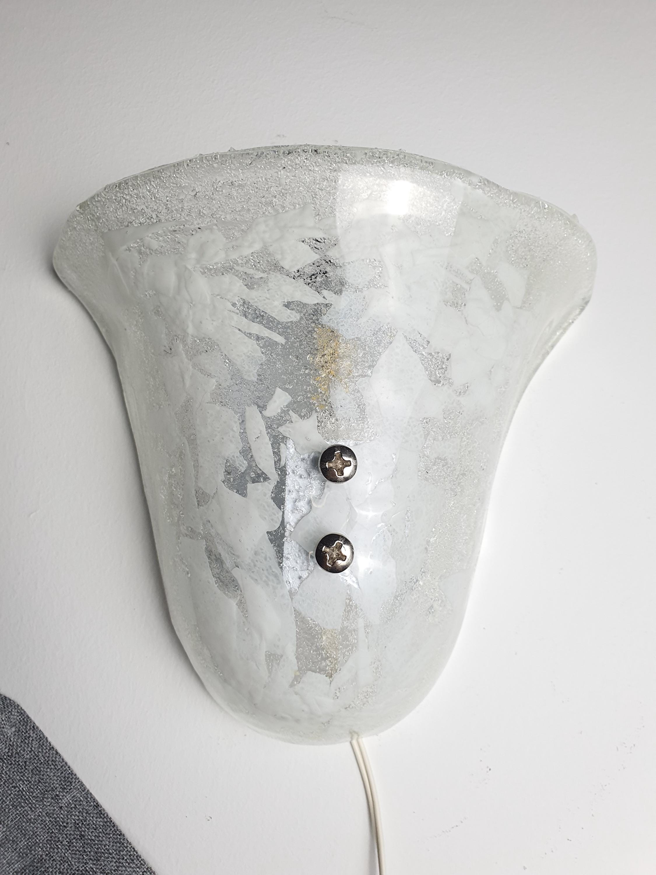 Murano glass shell sconce front view, clear glass with white inclusions, dual smooth and satin finish, white backplate