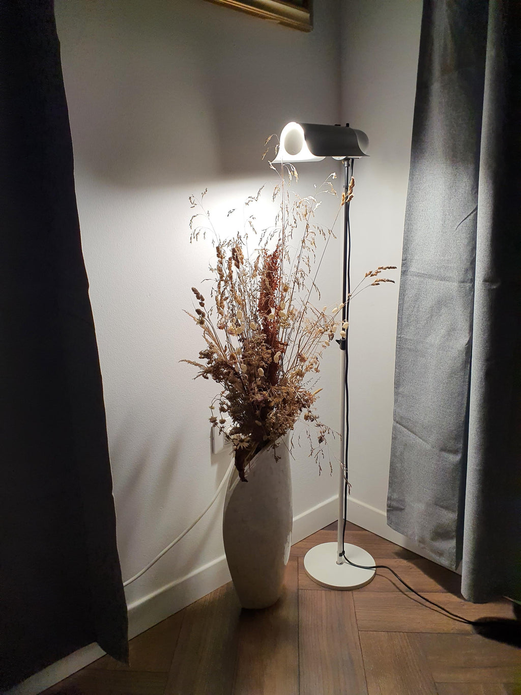 Vintage Italian white swing visor floor lamp lit, warm directed glow, Mid-Century Modern minimalist interior