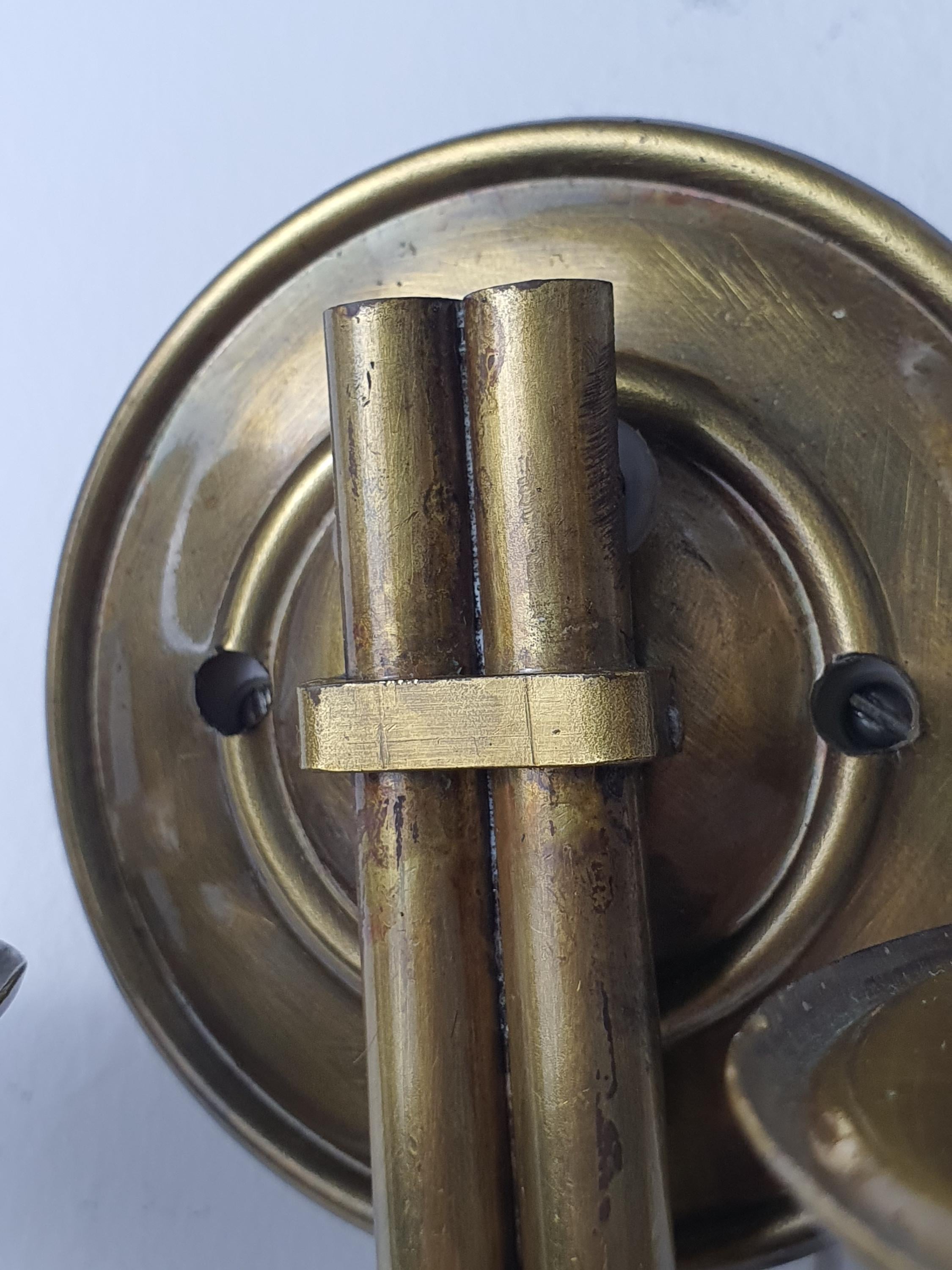 Close-up of natural patina on vintage Italian double-arm lacquered brass wall sconce, genuine aged brass character