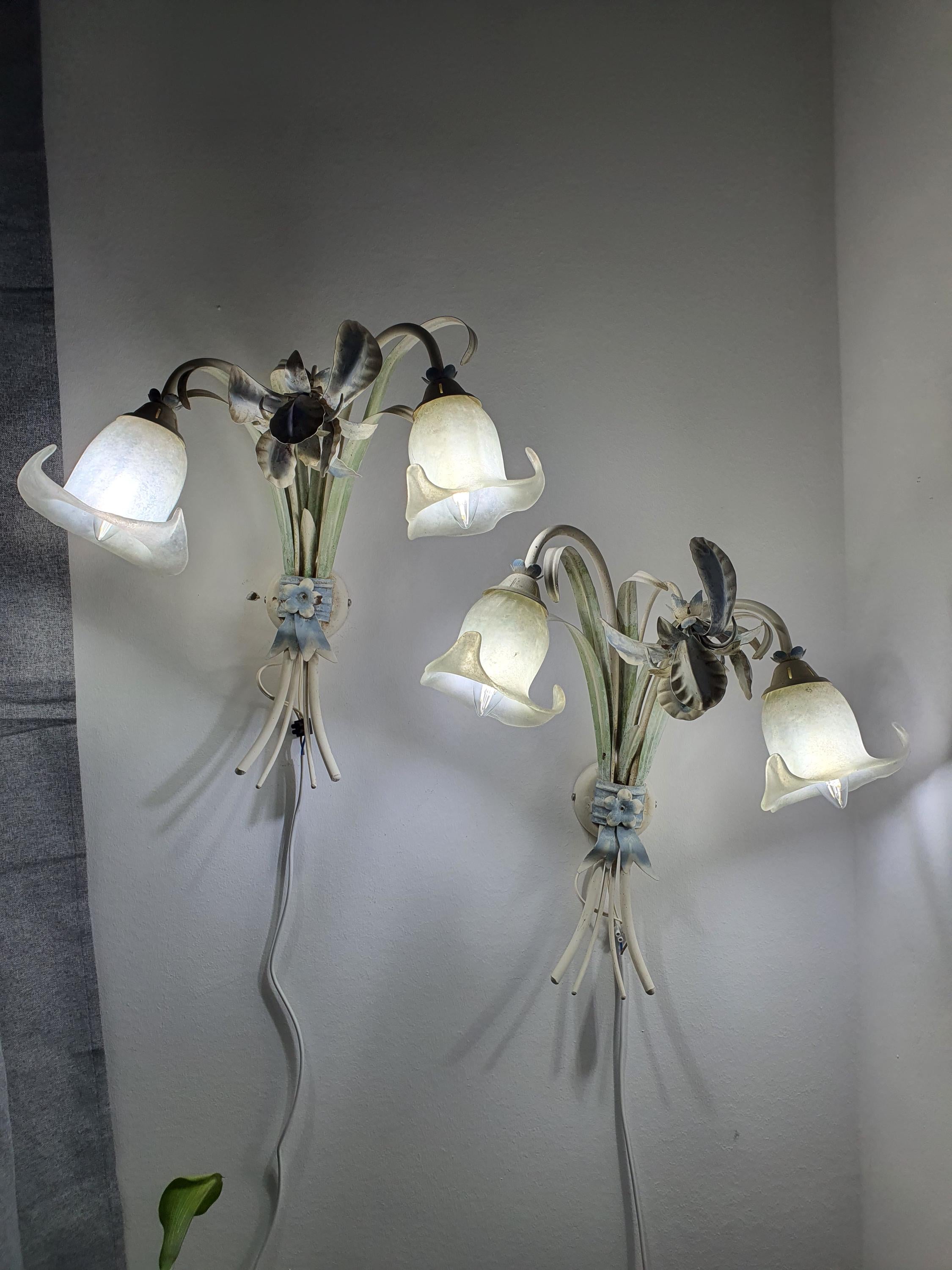 Vintage Italian toleware sconce — illuminated, warm ambient glow through floral metal composition