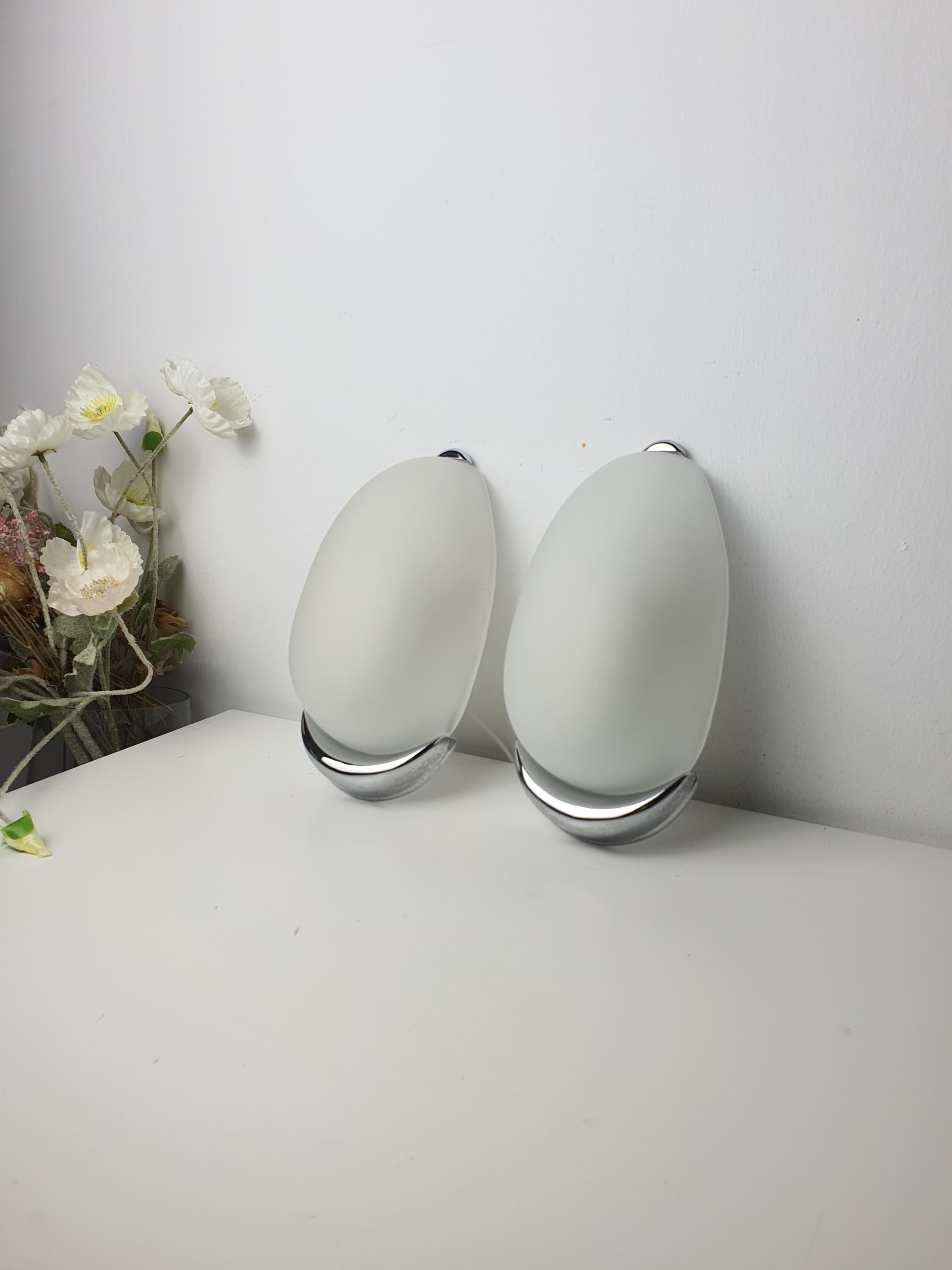 Vintage Italian egg-form wall sconces unlit, showing satin frosted glass capsule silhouette and chrome bases