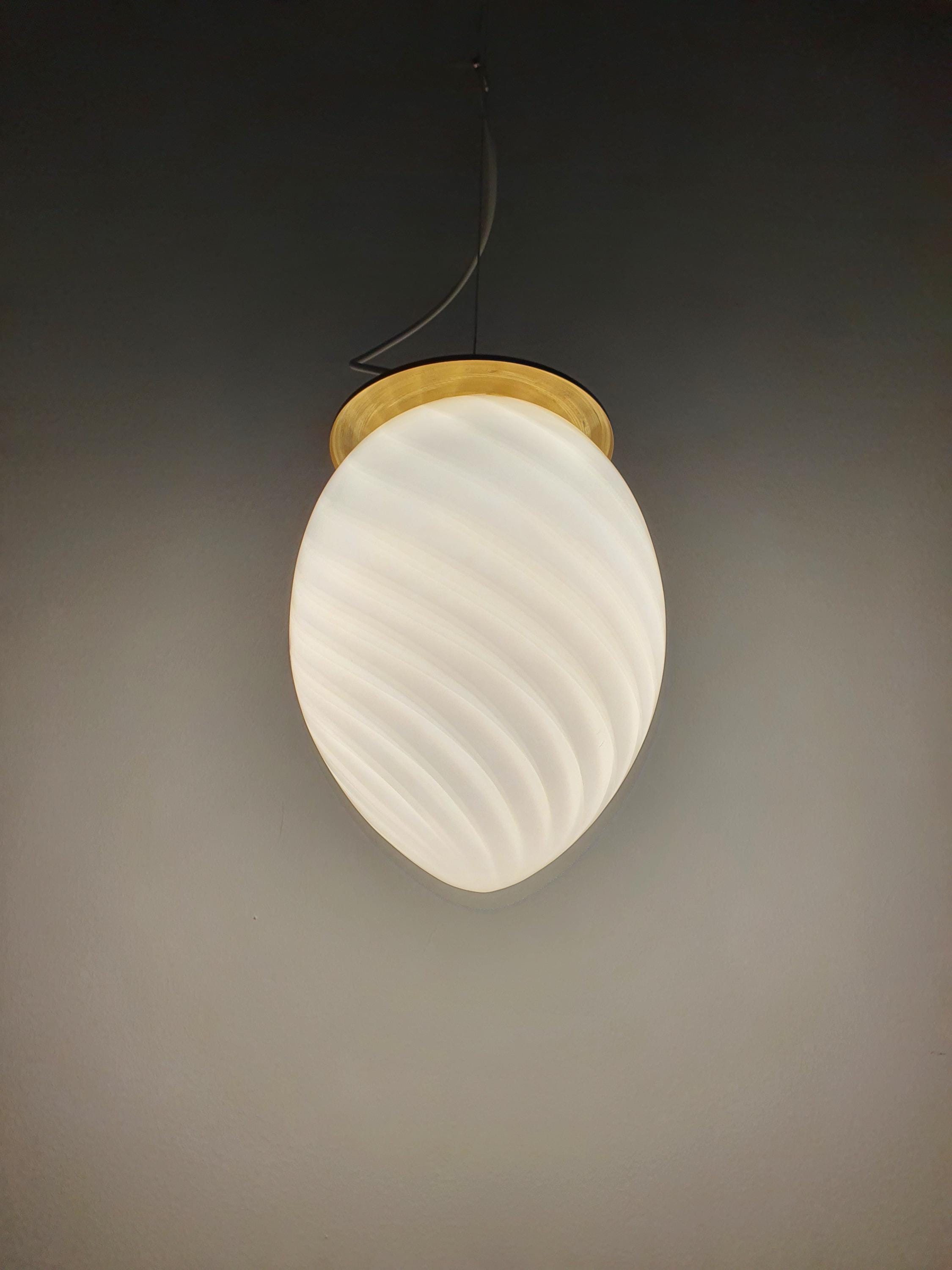 Vintage Murano white swirl egg pendant front view, egg-shaped silhouette, white swirl within glass, brass canopy and fittings