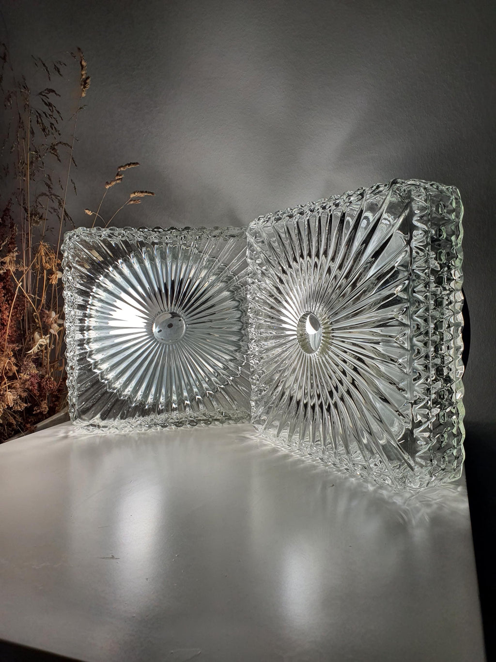 Square pressed-glass wall light with a silver-tone metal base

