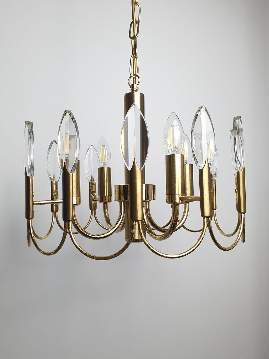 Sciolari-attributed 4-arm chandelier front view, four brass arms with double-wave motif, faceted crystal drops, golden finish