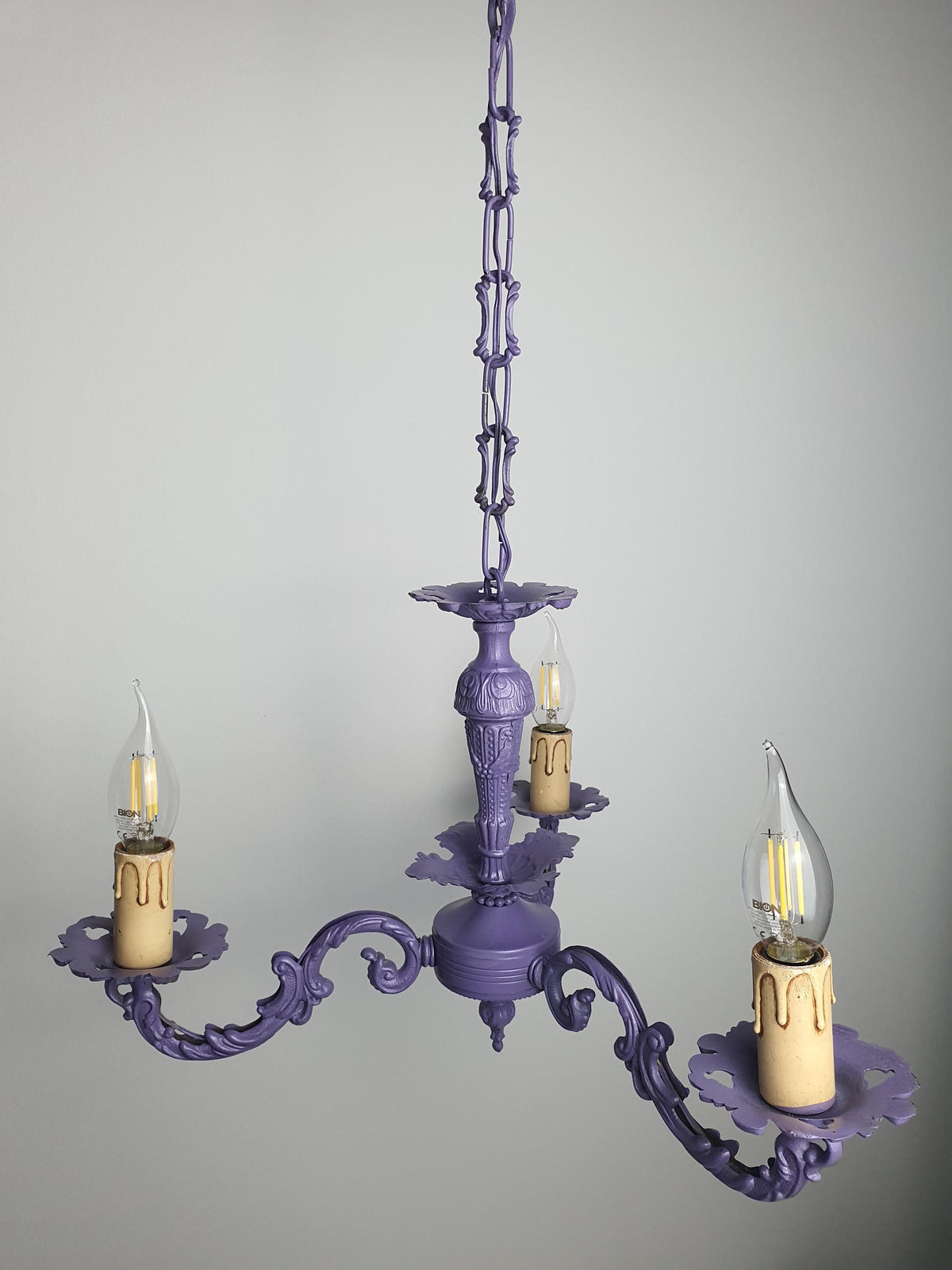 Decorative silhouette of a compact purple candle chandelier
